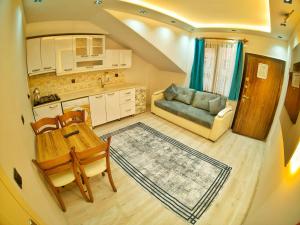 a kitchen and living room with a table and a couch at Kusva Apart in Uzungöl
