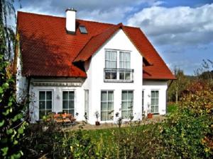 a white house with an orange roof at Feriendörfle Fritz - Ferienwohnung in Ettenbeuren