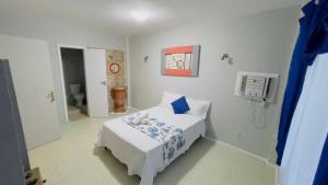 um quarto branco com uma cama e uma casa de banho em Casa Marina VIP em Búzios