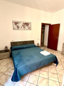 um quarto com uma cama com um cobertor azul em Mary T House em Campagnano di Roma