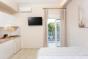 a bedroom with a bed and a kitchen with a window at Dimitra Central Apartments Chanioti in Hanioti