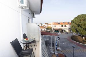 a balcony with two chairs and a table on a building at Dimitra Central Apartments Chanioti in Hanioti