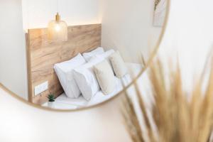 a mirror with white pillows on a shelf at Dimitra Central Apartments Chanioti in Hanioti +1 photo