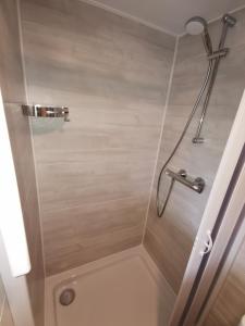 een douche in een badkamer met een glazen deur bij Chalet in Toskana Viareggio Italie nabij Zee, Strand, Airconditioning, Zwembad, Wifi in Viareggio