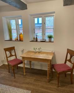 een keuken met een houten tafel en 2 stoelen bij Matrosenkoje in Flensburg