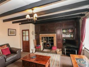 ein Wohnzimmer mit einem Sofa und einem Kamin in der Unterkunft Grimes Cottage in Staithes