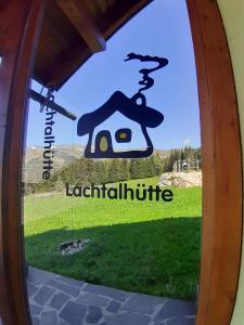 una ventana con un cartel que diga icolítico en Großzügiges Ferienhaus mit Sauna und Whirlpool, en Lachtal