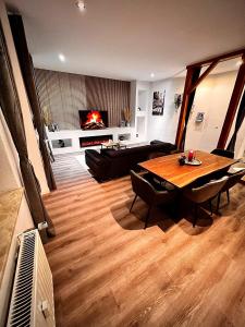 a living room with a wooden table and a fireplace at Modern City Suites in Oberhausen