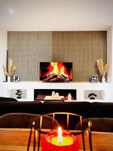 a living room with a couch with a tv and a candle at Modern City Suites in Oberhausen