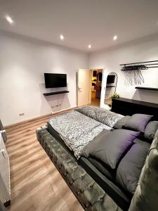 a bedroom with a large bed and a flat screen tv at Modern City Suites in Oberhausen