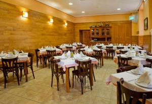a dining room with tables and chairs with white napkins at Hotel Restaurante La Casilla in Cangas del Narcea