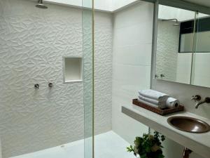 ein Bad mit einer Dusche, einem Waschbecken und einem Spiegel in der Unterkunft La Masia Hotel Boutique in Anapoima