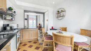 una cucina con tavolo e sedie in una stanza di HOMEY COLOC GATSBY - New, parking gratuit, proche gare, Balcons privés, Établissement élégant et moderne a Ville-la-Grand