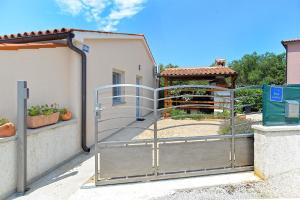 um portão sobre uma cerca com um jardim em Ferienhaus für 4 Personen ca 37 qm in Peroj, Istrien Istrische Riviera em Peroj