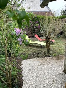 un jardín con un banco y flores en el césped en Le gîte du Tremblay, en Étais-la-Sauvin