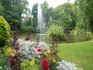 a fountain in the middle of a garden with flowers at Le Jardin des Plantes in Nantes +3 photos