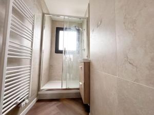 a bathroom with a walk in shower and a window at Le Jardin des Plantes in Nantes