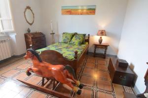 a bedroom with a bed with a wooden horse on the floor at grande appartamento in versilia in Camaiore
