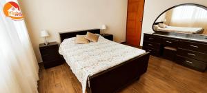 1 dormitorio con cama y espejo grande en NatAle Residencial - Departamento Primer Piso con cochera, en Tacna