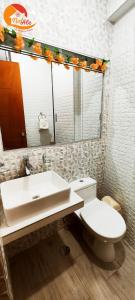 y baño con lavabo, aseo y espejo. en NatAle Residencial - Departamento Primer Piso con cochera en Tacna