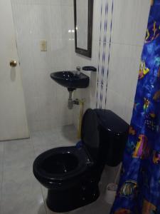 a bathroom with a black toilet and a sink at Apartamento a 20 minutos del aeropuerto in Bogotá
