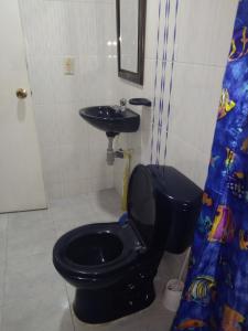 a bathroom with a black toilet and a sink at Apartamento a 20 minutos del aeropuerto in Bogotá