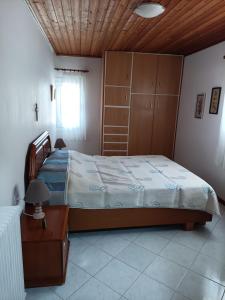 1 dormitorio con 1 cama grande y techo de madera en Stef Panorama House, en Loutraki