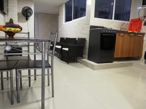 eine Küche mit einem Tisch und einem schwarzen Herd in der Unterkunft A un paso del mar 2 in Cartagena de Indias