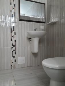 ein Badezimmer mit einem Waschbecken, einem WC und einem Spiegel in der Unterkunft A un paso del mar 2 in Cartagena de Indias