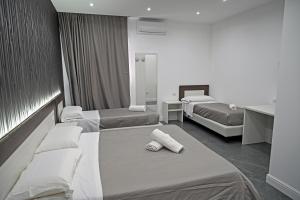 una camera d'albergo con due letti e asciugamani di Hotel Blanc a Casoria
