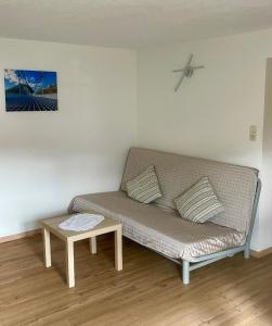 a couch in a living room with a table at Gemütliche Ferienwohnung in Pflach mit Garten in Pflach