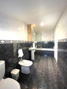 łazienka z toaletą, umywalką i wanną w obiekcie Boutique Hotel Jardim Do Mar w mieście Jardim do Mar