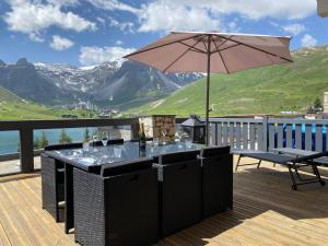 a table with an umbrella on a deck with mountains at Appartement Tignes, 3 pièces, 4 personnes - FR-1-641-35 in Tignes