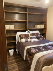 a bedroom with a bed and shelves in it at Whiteshomesplus in Joplin