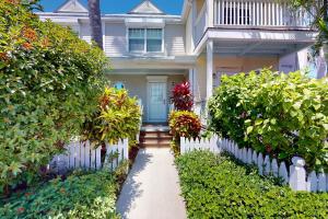 a house with a white fence and a pathway at Coconut House in Duck Key