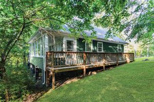 a green house sitting in the middle of a yard at Cozy Cottage on wooded lot with Hot Tub & Fire Pit in Front Royal