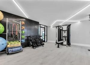 a gym with several treadmills and equipment in a room at Cozy Two-Bedroom Two-Bathroom Stay in the Heart of Rochester Hills in Rochester Hills