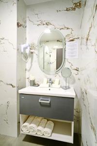 a bathroom with a sink and a mirror at Hotel Sir Royal in Bucharest +12 photos