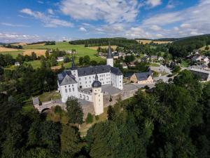 an aerial view of a large white building with a tower at Schloss Purschenstein in Neuhausen