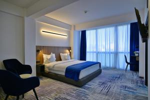 Hotel Sir Royal في بوخارست: غرفة نوم بسرير ومكتب وكرسي