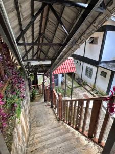 a building with a wooden walkway with a roof at Hillside cottage chalet studio in Tanah Rata