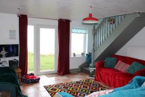a living room with a red couch and a staircase at The Beach House in Newry