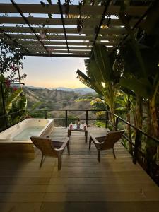 a deck with a tub and chairs and a view at Flor del Monte in Sopetran