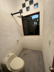a bathroom with a toilet and a window at Flor del Monte in Sopetran