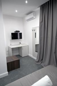een witte kamer met een bed en een televisie bij Hotel Blanc in Casoria