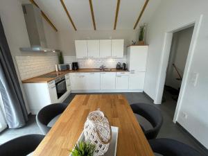 a kitchen with a wooden table and some chairs at G1 Eingezäuntes Haus mit Kamin in Eckwarderhörne in Großwürden