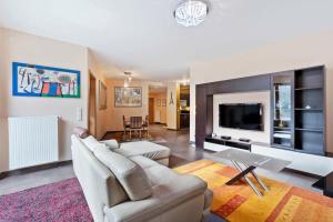 a living room with a couch and a tv at Stylish 2-Bed Gem, Nature & Comfort in Luxembourg