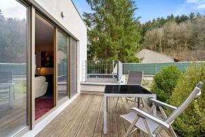 a patio with a table and chairs on a deck at Stylish 2-Bed Gem, Nature & Comfort in Luxembourg