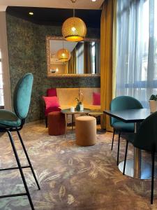 a room with tables and chairs and a mirror at Best Western Allegro Nation in Paris