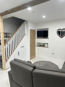 a living room with a couch and a tv at Lewys Ty Bach in Aberaman